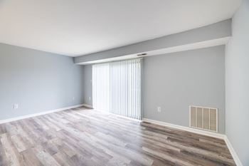 A room with wooden flooring and a window with blinds at BellaVista Apartments in Woodbridge, VA